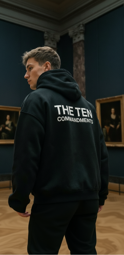 Person wearing a black hoodie with 'THE TEN COMMANDMENTS' text in an indoor setting.